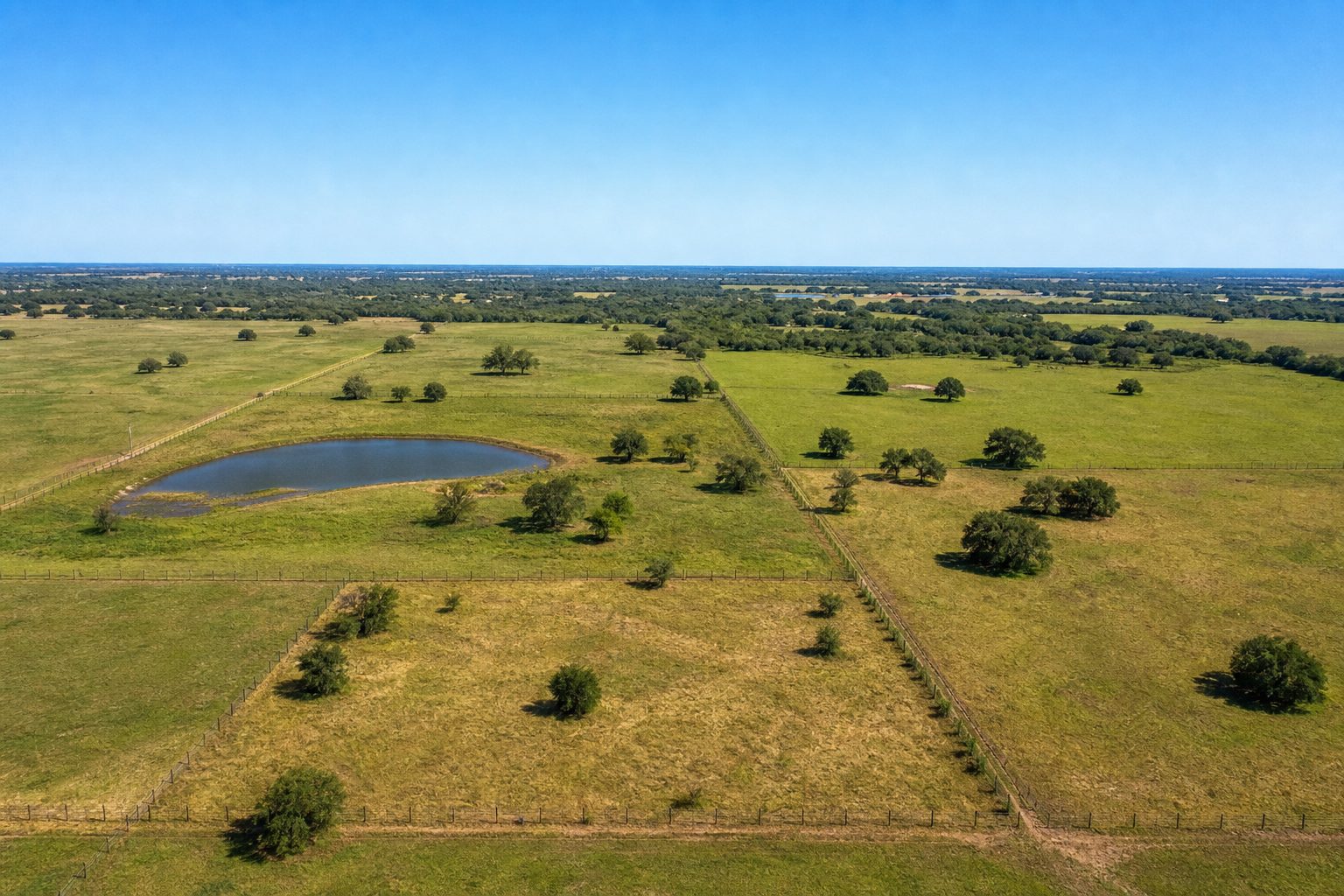 Concept aerial image of a subdivided rural Texas land tract with fence lines and a pond